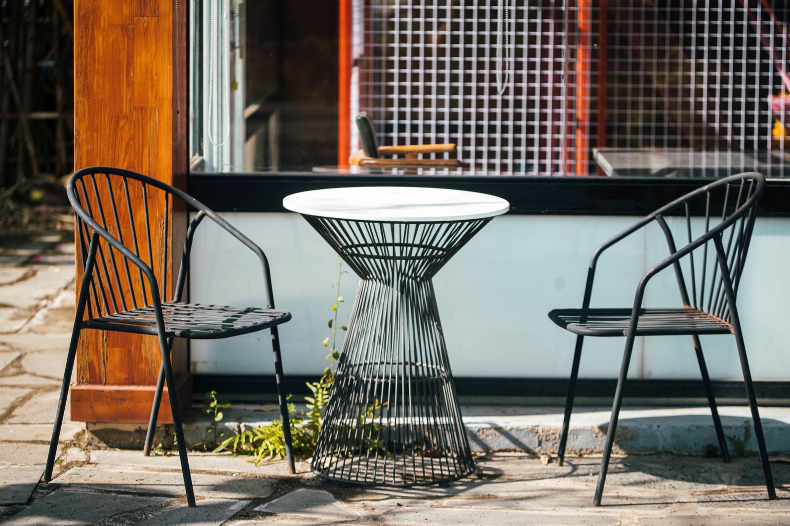 Terrasse avec chaises et table sur le trottoir.